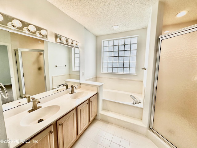 bathroom with vanity, shower with separate bathtub, and a textured ceiling