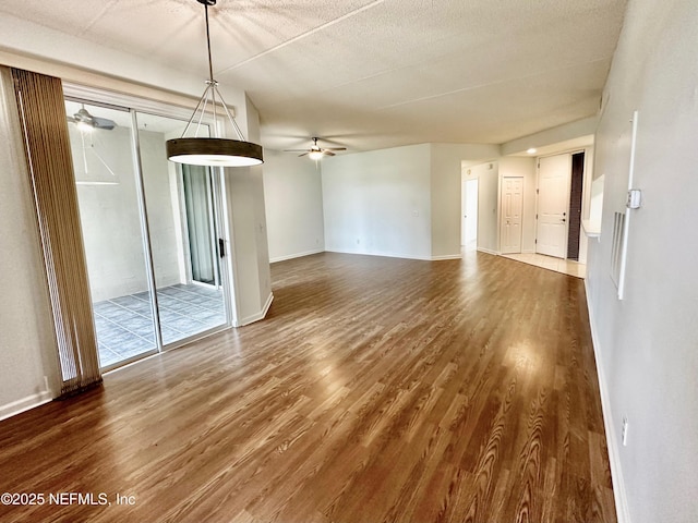 empty room with dark hardwood / wood-style flooring, a textured ceiling, and ceiling fan