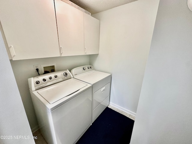 clothes washing area with cabinets, tile patterned floors, washer and dryer, and a textured ceiling