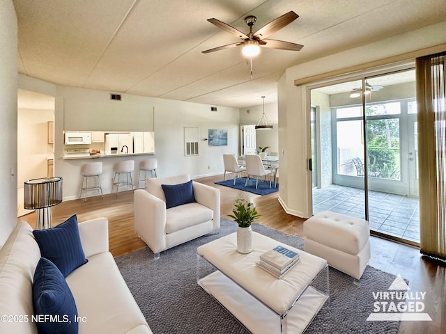 living room featuring hardwood / wood-style floors and ceiling fan