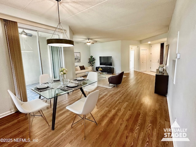 dining area with hardwood / wood-style flooring, a textured ceiling, and ceiling fan