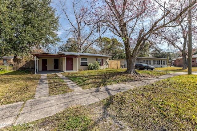 ranch-style house with a carport and a front lawn