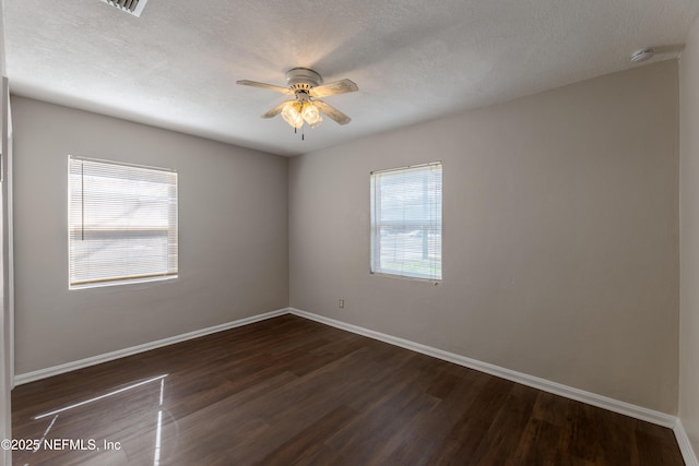 empty room with dark wood-type flooring, ceiling fan, and a textured ceiling