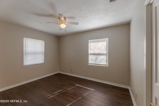 empty room featuring dark wood-type flooring, ceiling fan, and a textured ceiling