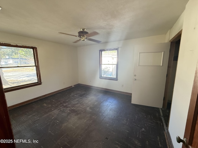 unfurnished room with dark hardwood / wood-style flooring, a wealth of natural light, and ceiling fan