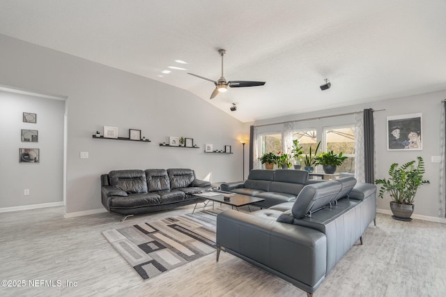 living room with lofted ceiling, a textured ceiling, light hardwood / wood-style floors, and ceiling fan