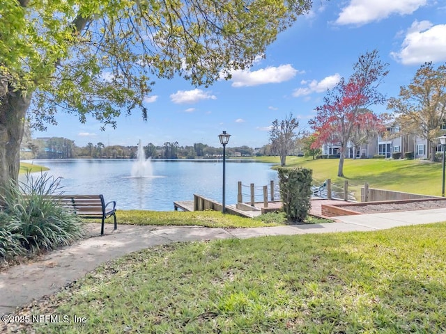 view of home's community featuring a water view and a lawn