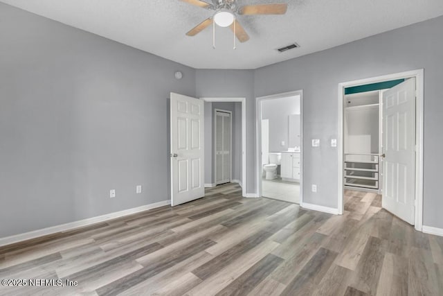 unfurnished bedroom featuring light wood-style floors, baseboards, and visible vents