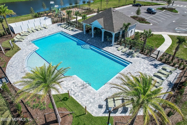 view of pool featuring a water view, a gazebo, and a patio area