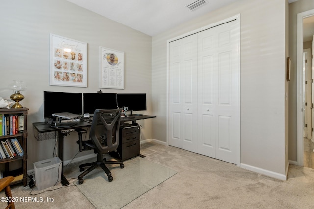 home office with vaulted ceiling and light colored carpet