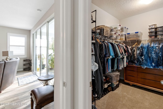 walk in closet with light hardwood / wood-style flooring