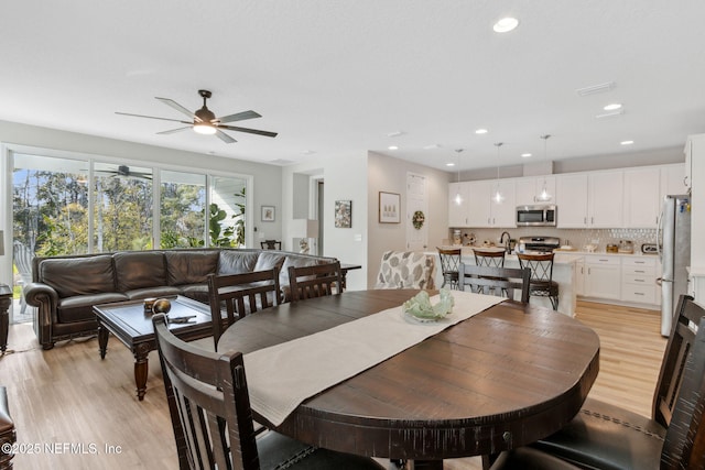 dining area featuring ceiling fan and light wood-type flooring