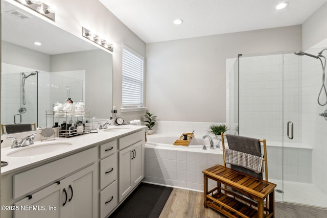 bathroom featuring hardwood / wood-style flooring, shower with separate bathtub, and vanity