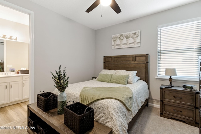 bedroom with sink, ensuite bath, light hardwood / wood-style flooring, and ceiling fan