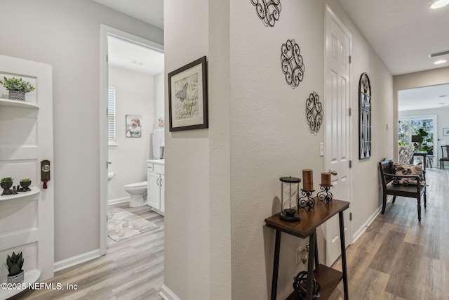 hallway featuring a healthy amount of sunlight and light wood-type flooring