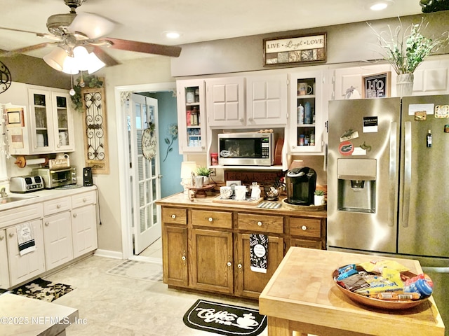 kitchen featuring white cabinetry, ceiling fan, appliances with stainless steel finishes, and sink