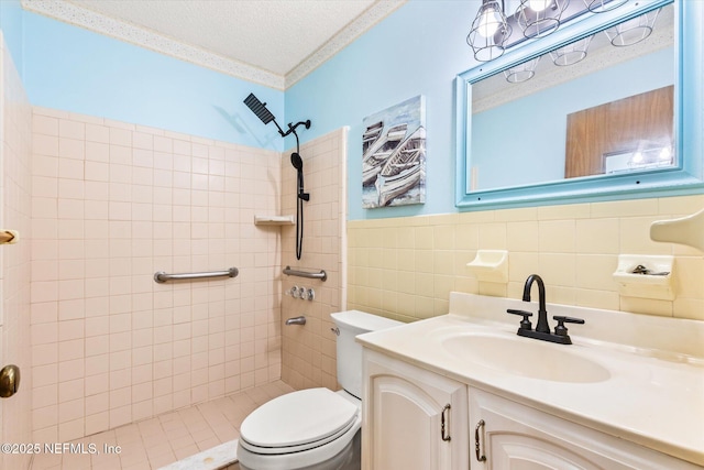 bathroom with a tile shower, tile walls, vanity, toilet, and a textured ceiling