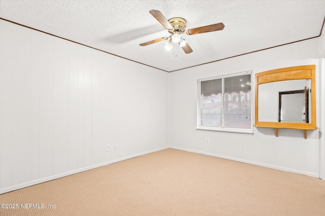 carpeted empty room featuring ceiling fan and a textured ceiling