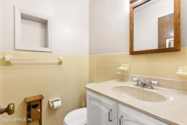 bathroom with vanity, tile walls, and toilet