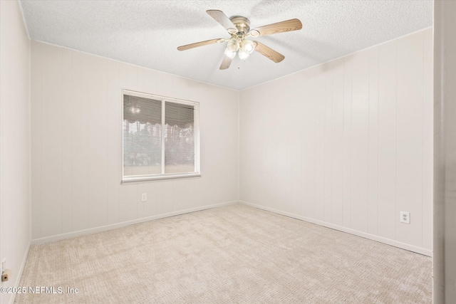 spare room with ceiling fan, light colored carpet, and a textured ceiling