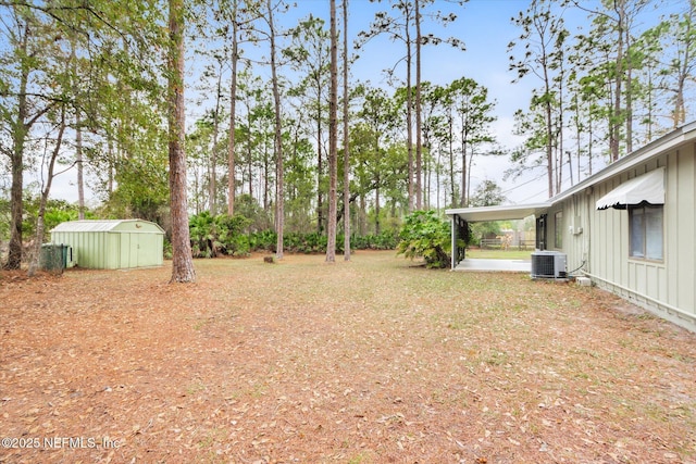 view of yard with a storage shed, central AC, and a carport