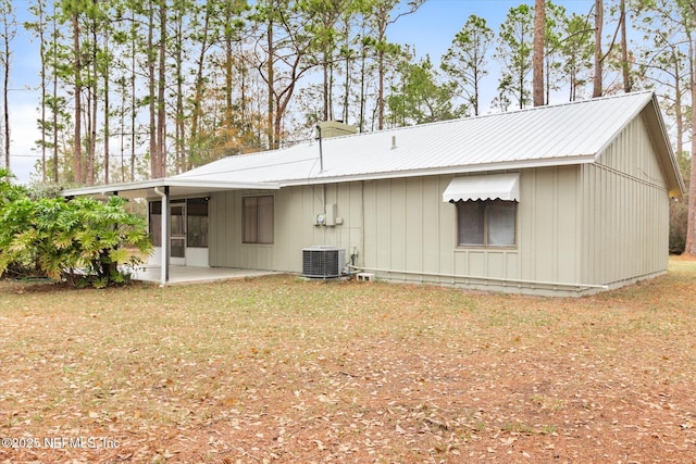 back of house featuring central AC, a patio, and a lawn