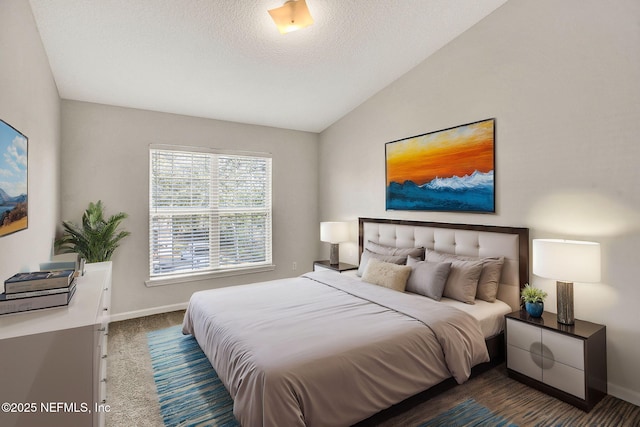 bedroom with vaulted ceiling, a textured ceiling, and dark colored carpet