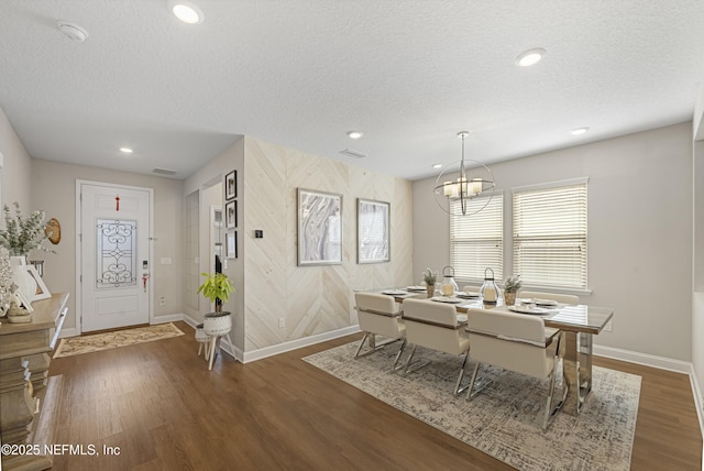 dining room with dark hardwood / wood-style flooring, a chandelier, and a textured ceiling