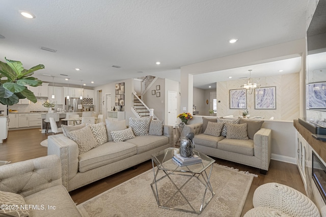 living room with dark hardwood / wood-style floors, a chandelier, and a textured ceiling