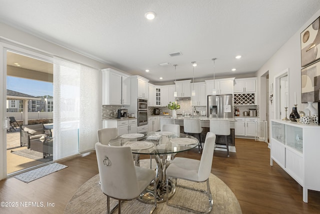 dining room with dark hardwood / wood-style flooring, sink, and a textured ceiling