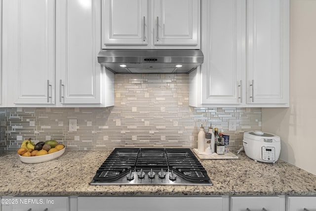 kitchen with stainless steel gas cooktop, exhaust hood, and white cabinets