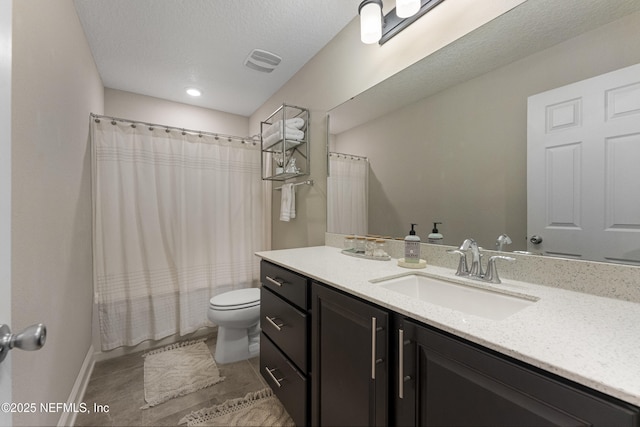 full bathroom with vanity, shower / bath combo, a textured ceiling, and toilet