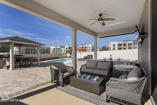 view of patio featuring a fenced in pool, an outdoor bar, ceiling fan, a gazebo, and an outdoor hangout area