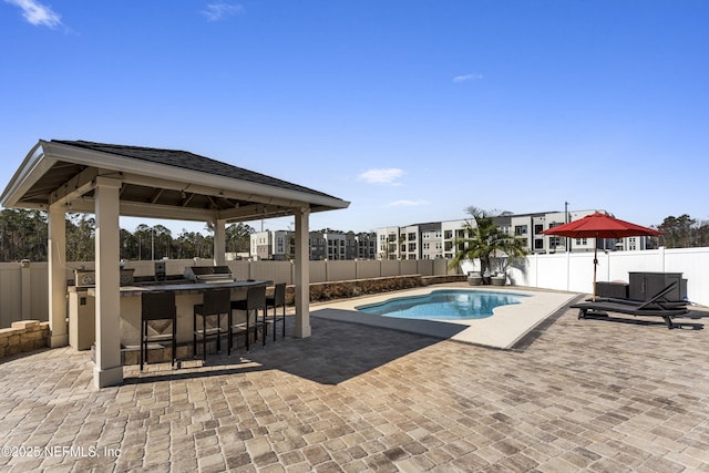 view of swimming pool with a gazebo, an outdoor bar, grilling area, and a patio area