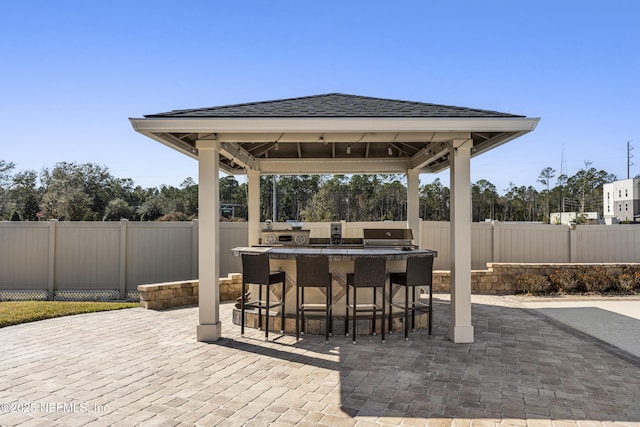 view of patio / terrace featuring a gazebo, an outdoor kitchen, and an outdoor bar