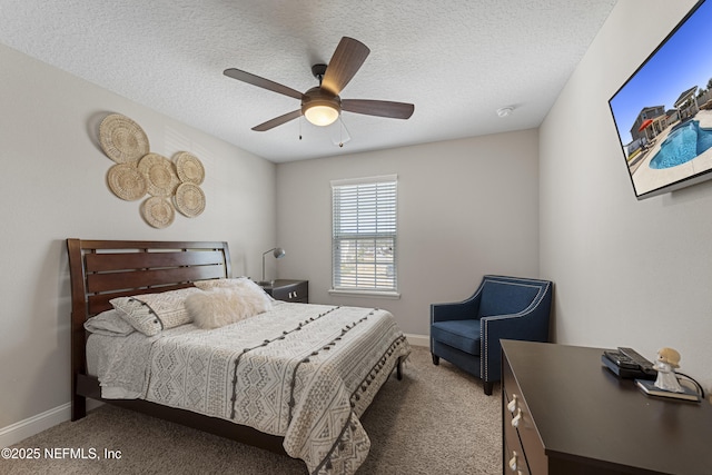 bedroom with ceiling fan, carpet floors, and a textured ceiling