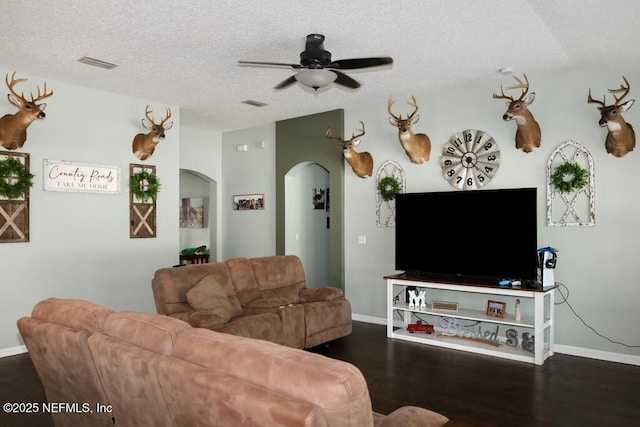 5452 Huckleberry Ct, Macclenny, FL 32063 - living room with arched walkways, a ceiling fan, a textured ceiling, baseboards, and wood finished floors
