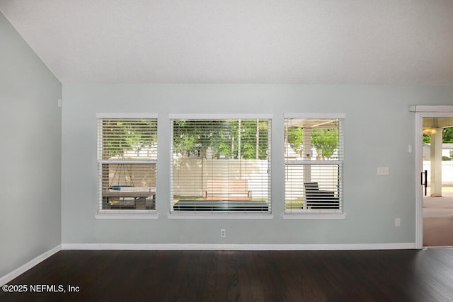 5452 Huckleberry Ct, Macclenny, FL 32063 - empty room featuring baseboards, dark wood finished floors, and vaulted ceiling
