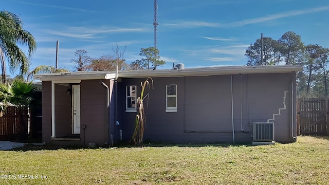 back of property featuring a lawn and central air condition unit