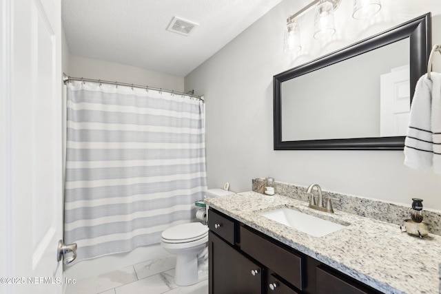 bathroom with vanity, toilet, and a textured ceiling