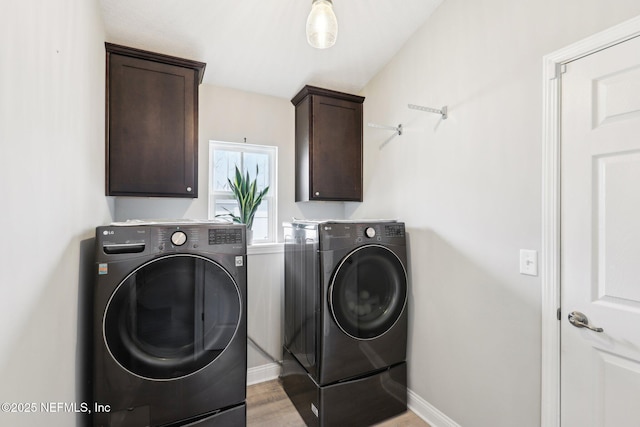 washroom with cabinets, independent washer and dryer, and light hardwood / wood-style flooring