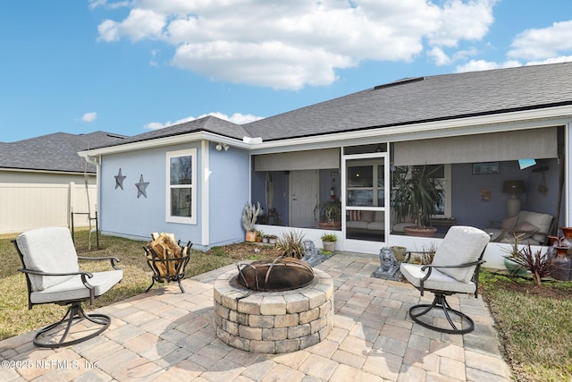 view of patio / terrace with a fire pit and a sunroom