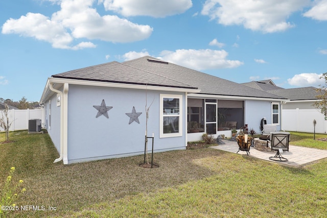 rear view of property with central AC unit, a fire pit, a patio area, and a lawn