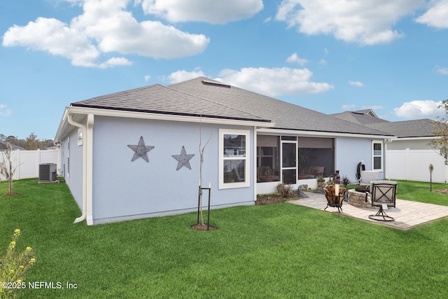 back of house featuring a fire pit, a yard, a patio area, a sunroom, and central air condition unit