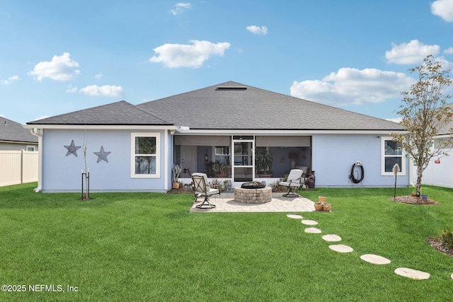 rear view of house featuring a patio, a lawn, and a fire pit