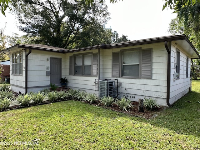 view of side of property featuring cooling unit and a lawn