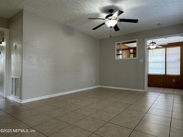 spare room featuring light tile patterned flooring, ceiling fan, and a textured ceiling