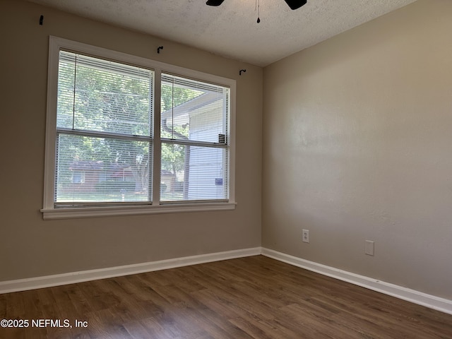 spare room featuring ceiling fan, dark hardwood / wood-style floors, and a textured ceiling