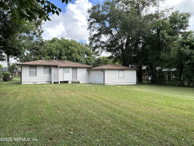 back of house with a yard and an outdoor structure