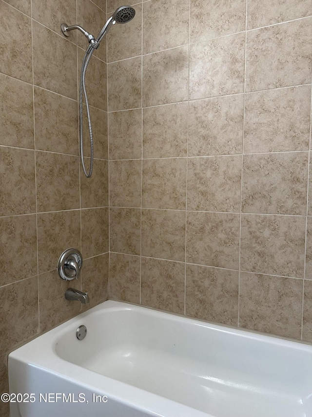 bathroom with tiled shower / bath combo